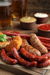 Set of different tasty snacks on wooden table, closeup view