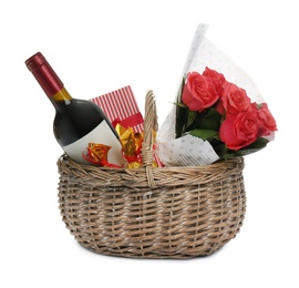 Photo of Wicker basket with gift, bouquet and wine on white background