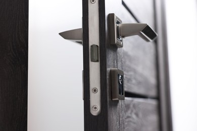 Photo of Open wooden door with metal handle, closeup