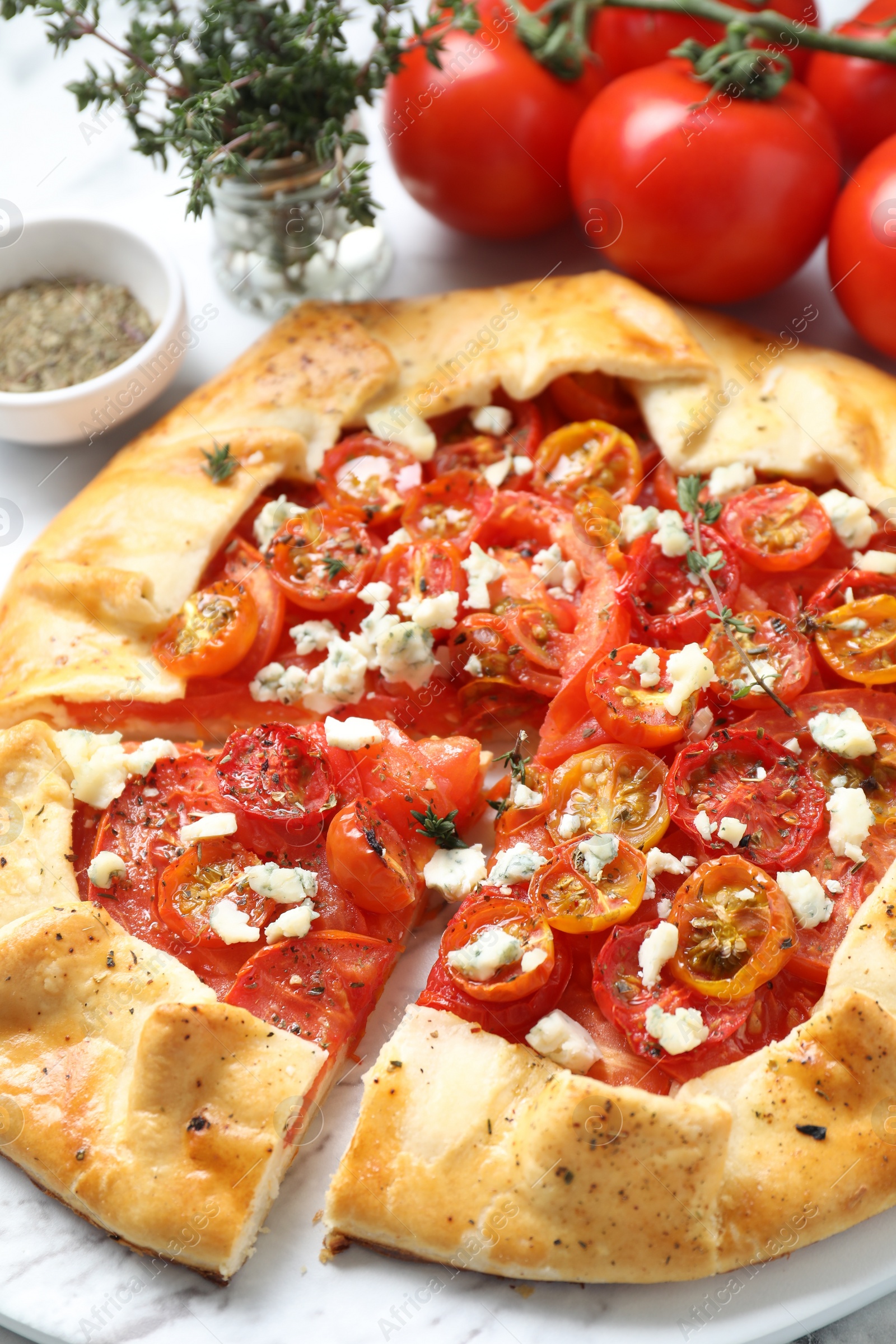 Photo of Tasty galette with tomato, thyme and cheese (Caprese galette) on white table, closeup
