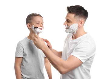 Dad pretending to shave his little son on white background