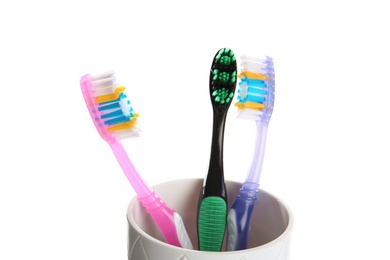 Photo of Cup with different toothbrushes on white background. Dental care