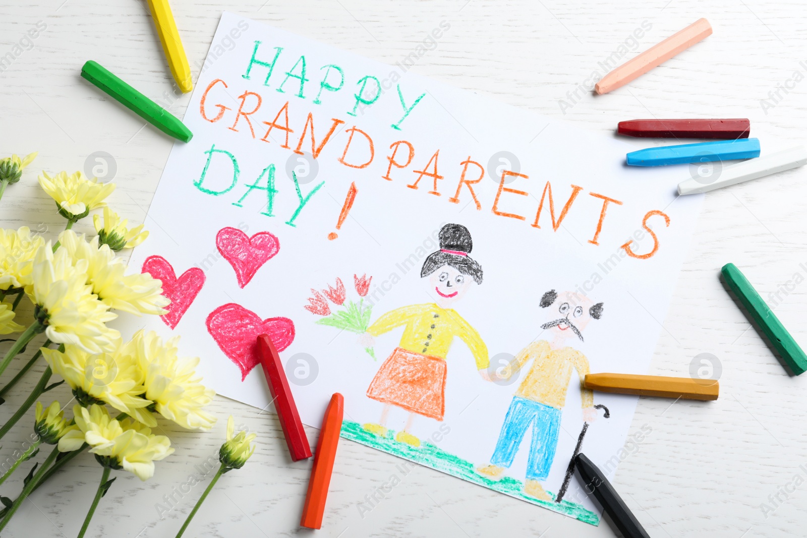 Photo of Beautiful drawing with phrase Happy Grandparents Day on white table, flat lay