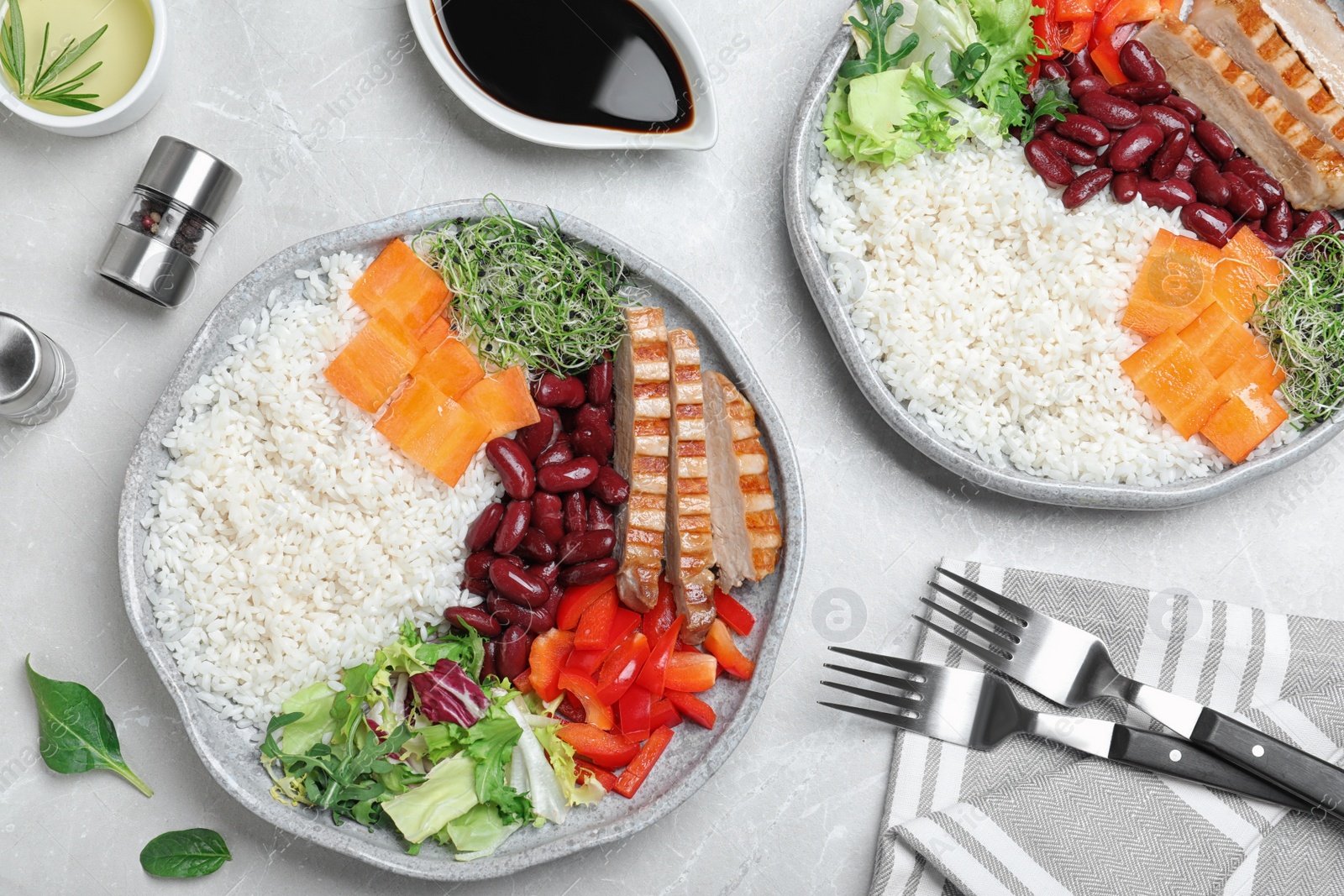 Photo of Tasty rice with beans and chicken meat served on light grey marble table, flat lay