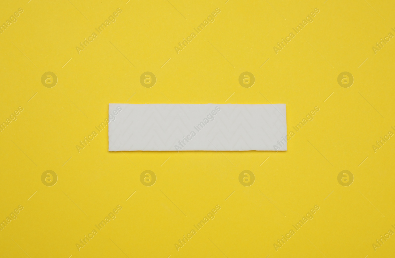 Photo of Stick of tasty chewing gum on yellow background, top view