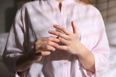 Photo of Woman taking off wedding ring indoors, closeup. Divorce concept