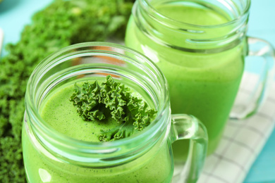 Photo of Tasty fresh kale smoothie on table, closeup