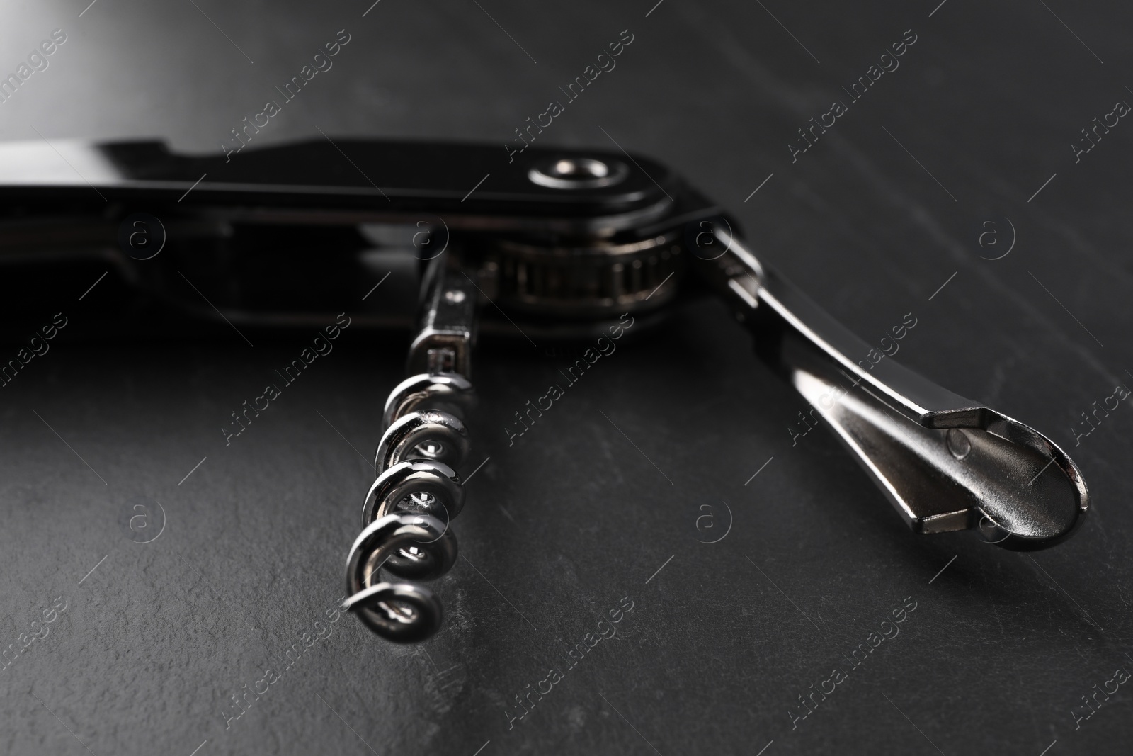 Photo of One corkscrew (sommelier knife) on grey textured table, closeup