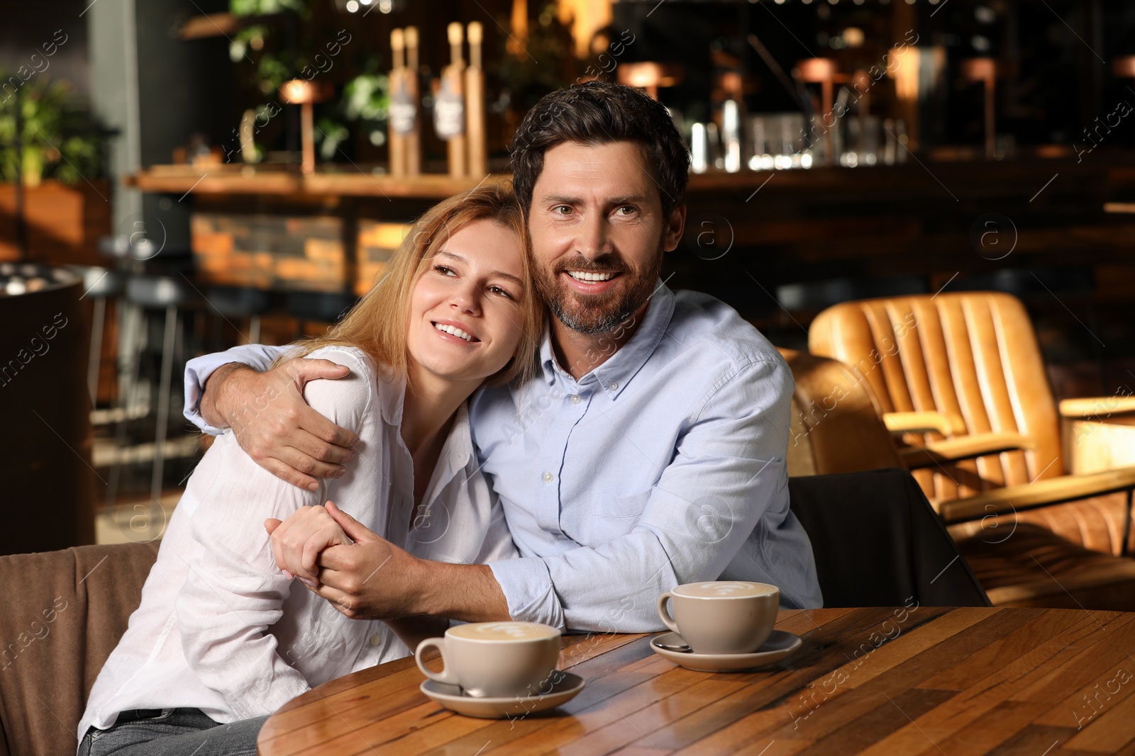 Photo of Romantic date. Lovely couple spending time together in cafe