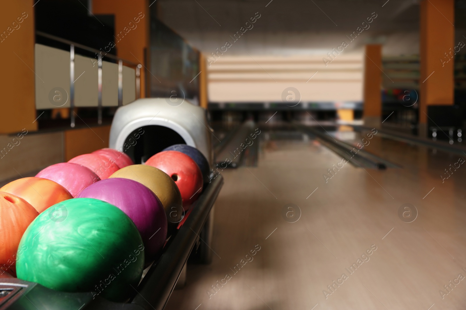 Photo of Rack with different balls in bowling club. Space for text