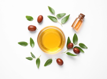 Photo of Bowl with jojoba oil and seeds on white background, top view