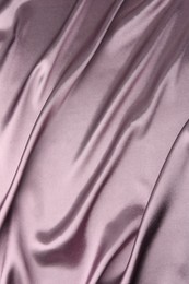 Crumpled dark purple silk fabric as background, top view