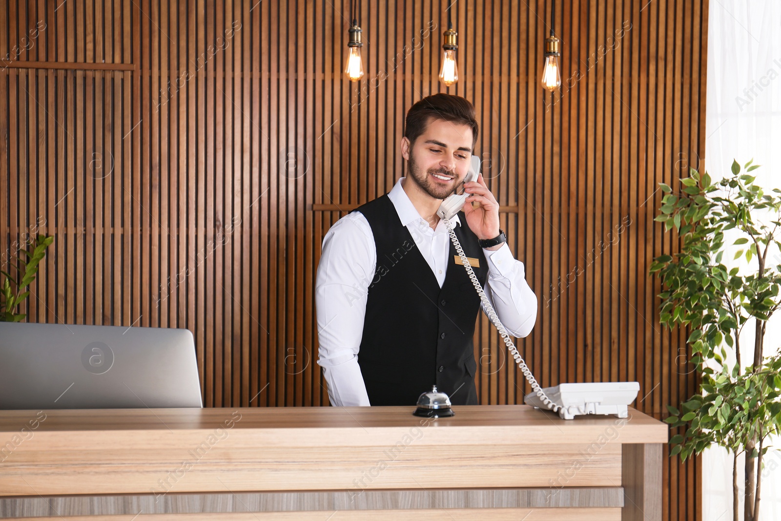 Photo of Receptionist talking on phone at desk in lobby