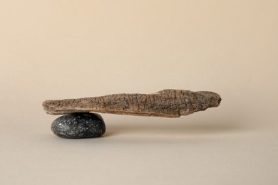 Photo of Stone with tree branch on beige background. Harmony and balance concept