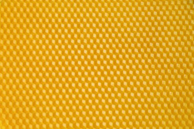 Natural beeswax sheet as background, top view
