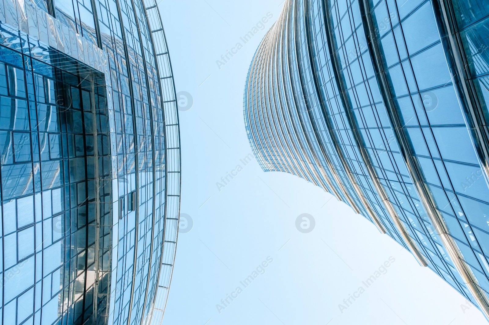 Photo of Stylish buildings with many windows under cloudy sky, low angle view