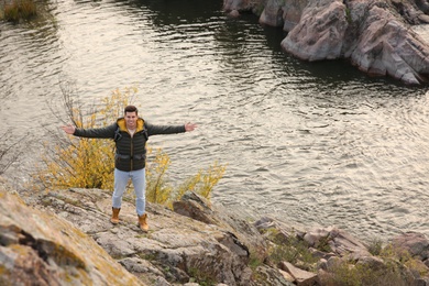 Man with backpack enjoying beautiful view near mountain river