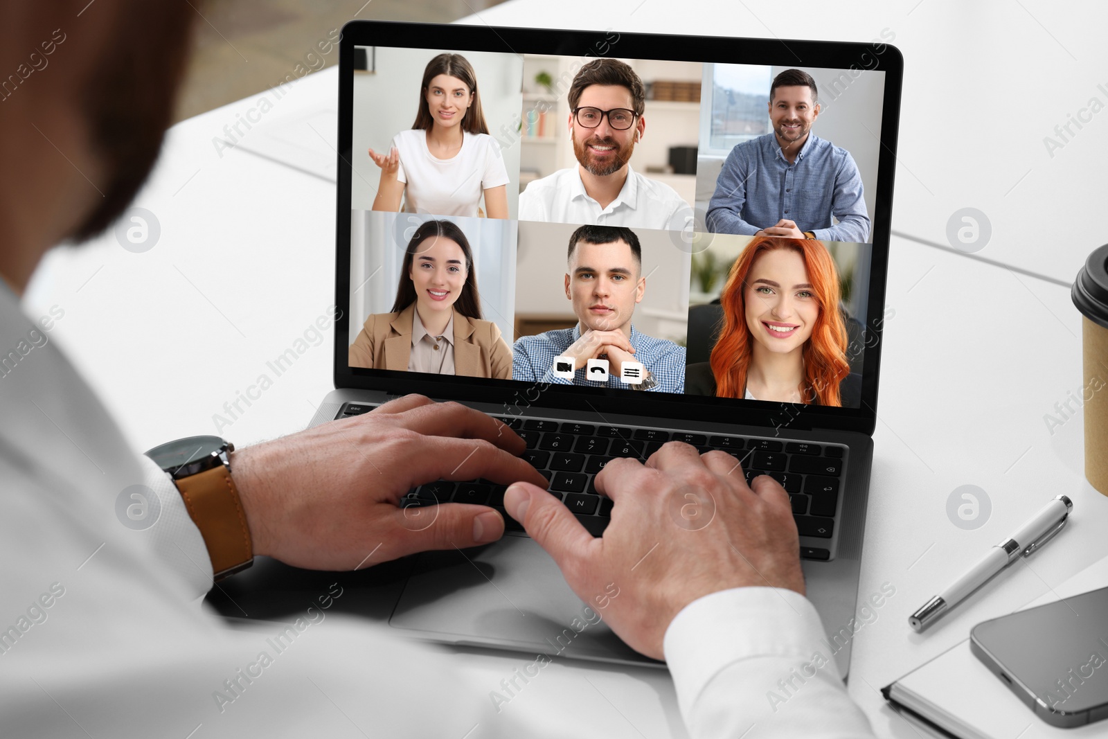 Image of Man having video chat with coworkers via laptop at white table, closeup