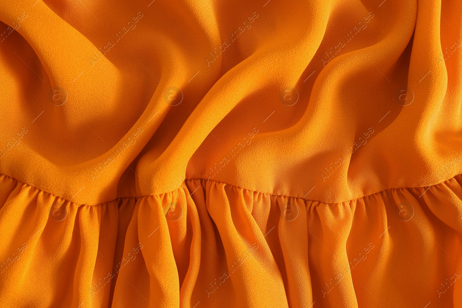 Photo of Texture of orange crumpled fabric as background, top view