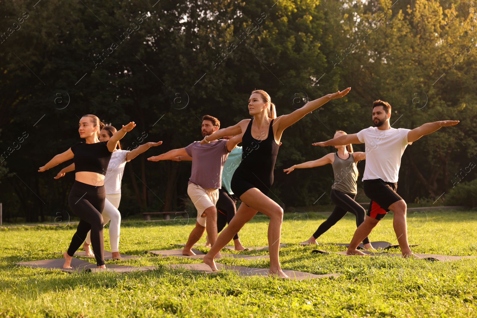 Photo of Group of people practicing yoga on mats outdoors