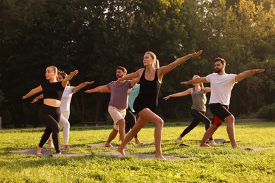 Photo of Group of people practicing yoga on mats outdoors