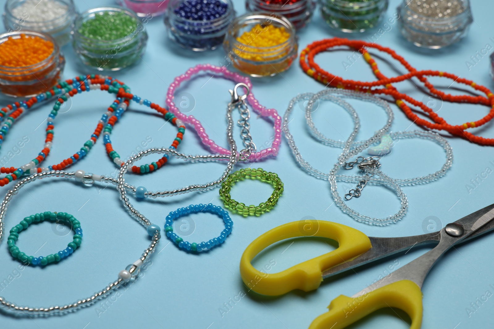 Photo of Composition with different colorful beads on light blue background