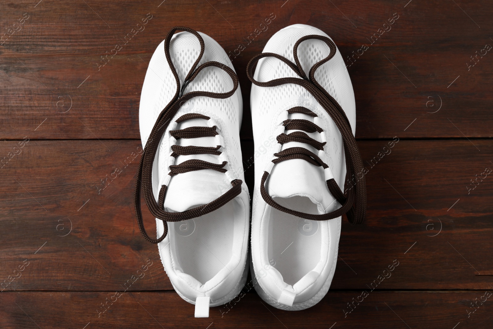 Photo of Pair of stylish shoes with laces on wooden background, flat lay