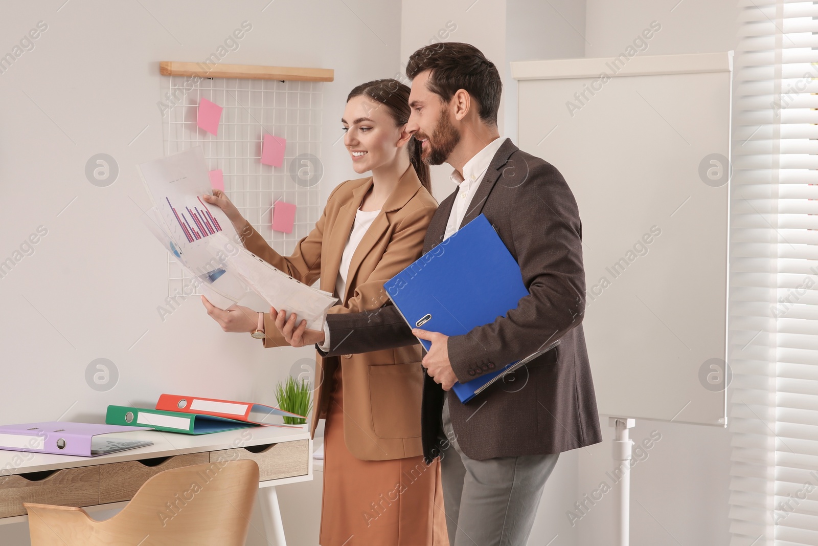 Photo of Businesspeople working together with charts in office