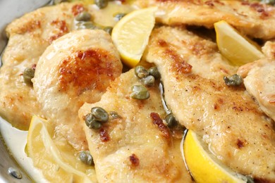 Delicious chicken piccata with lemons in pot, closeup