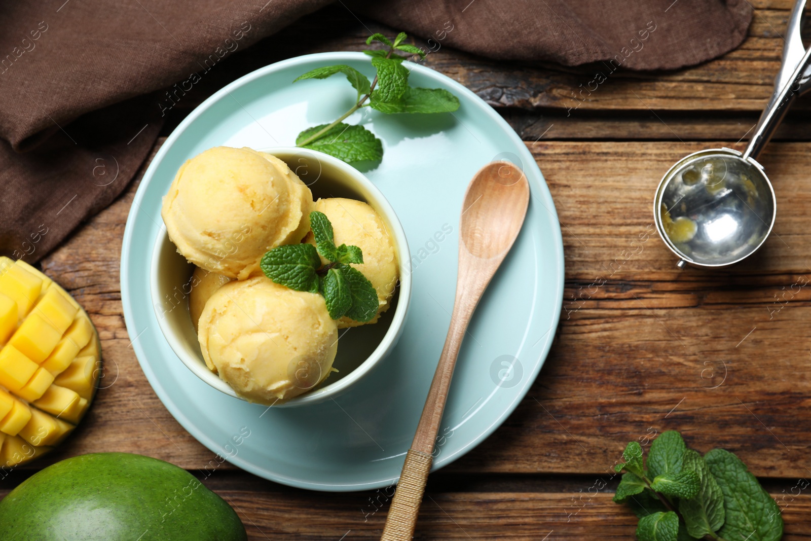 Photo of Delicious mango ice cream served on wooden table, flat lay