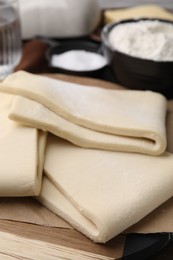 Photo of Raw puff pastry dough on table, closeup