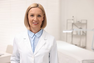 Portrait of happy dermatologist in modern clinic, space for text