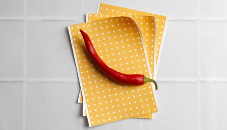 Photo of Pepper plasters and chili on white tiled table, top view