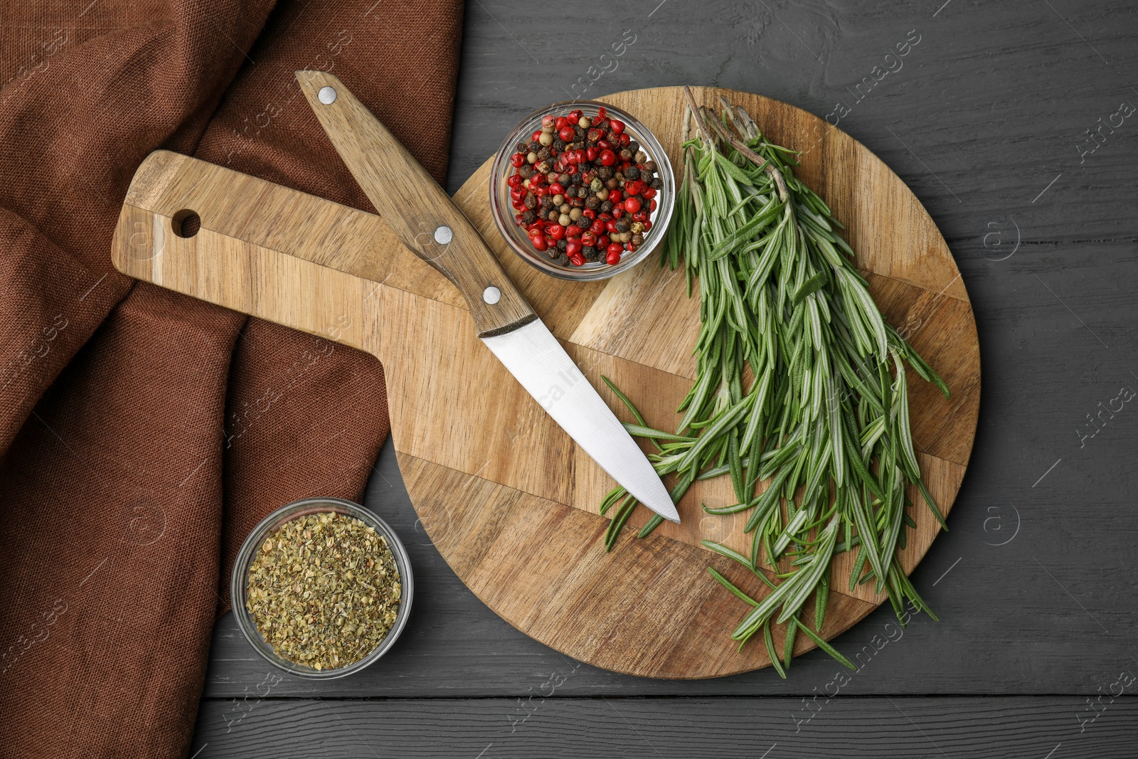 Photo of Wooden board, knife and spices on grey table, flat lay