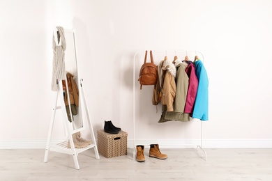 Modern hallway interior with mirror and clothes on hanger stand