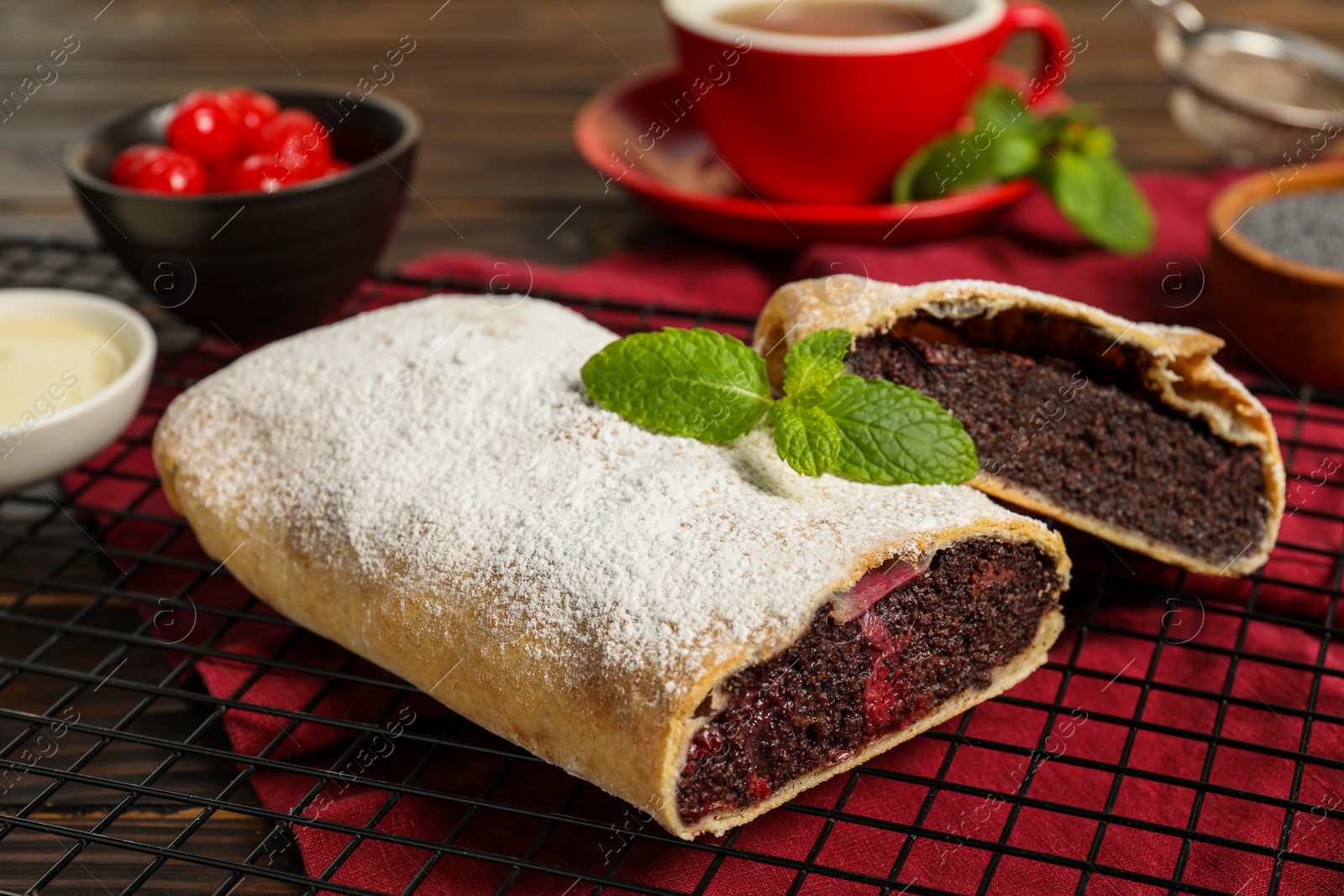 Photo of Delicious strudel with cherries and poppy seeds on table, closeup