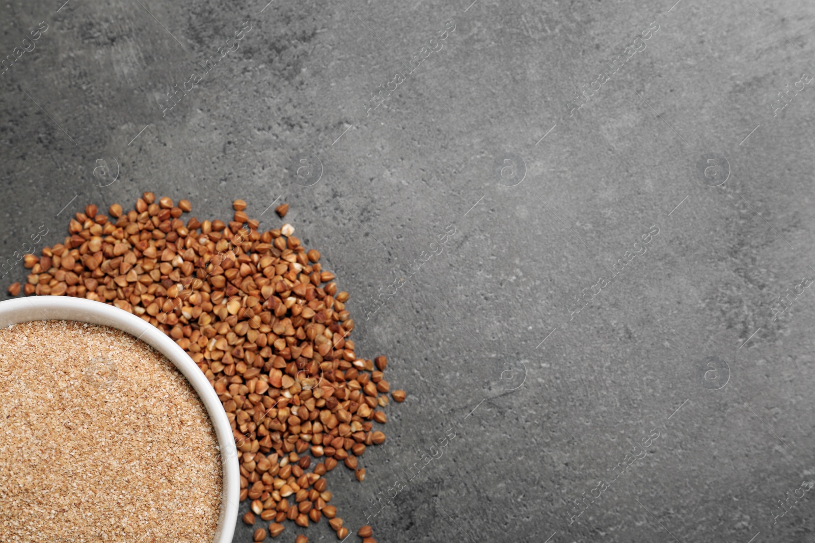 Photo of Bowl with buckwheat flour and seeds on grey background, top view. Space for text