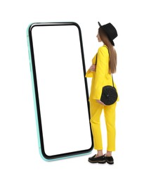 Woman standing in front of big smartphone on white background