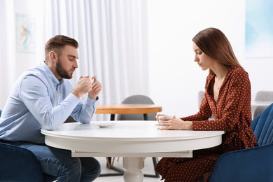 Couple with relationship problems at table in cafe