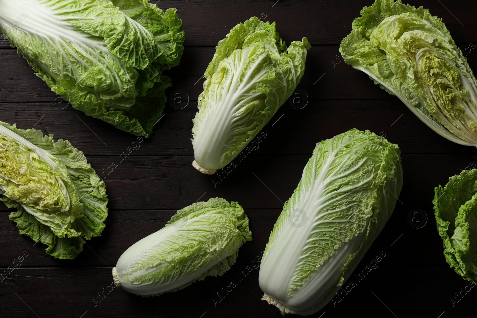 Photo of Fresh ripe Chinese cabbages on dark wooden table, fat lay