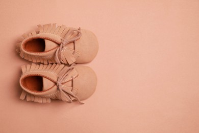 Photo of Cute baby shoes on brown background, flat lay. Space for text