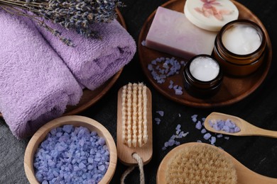 Composition with different spa products and lavender on black table, above view