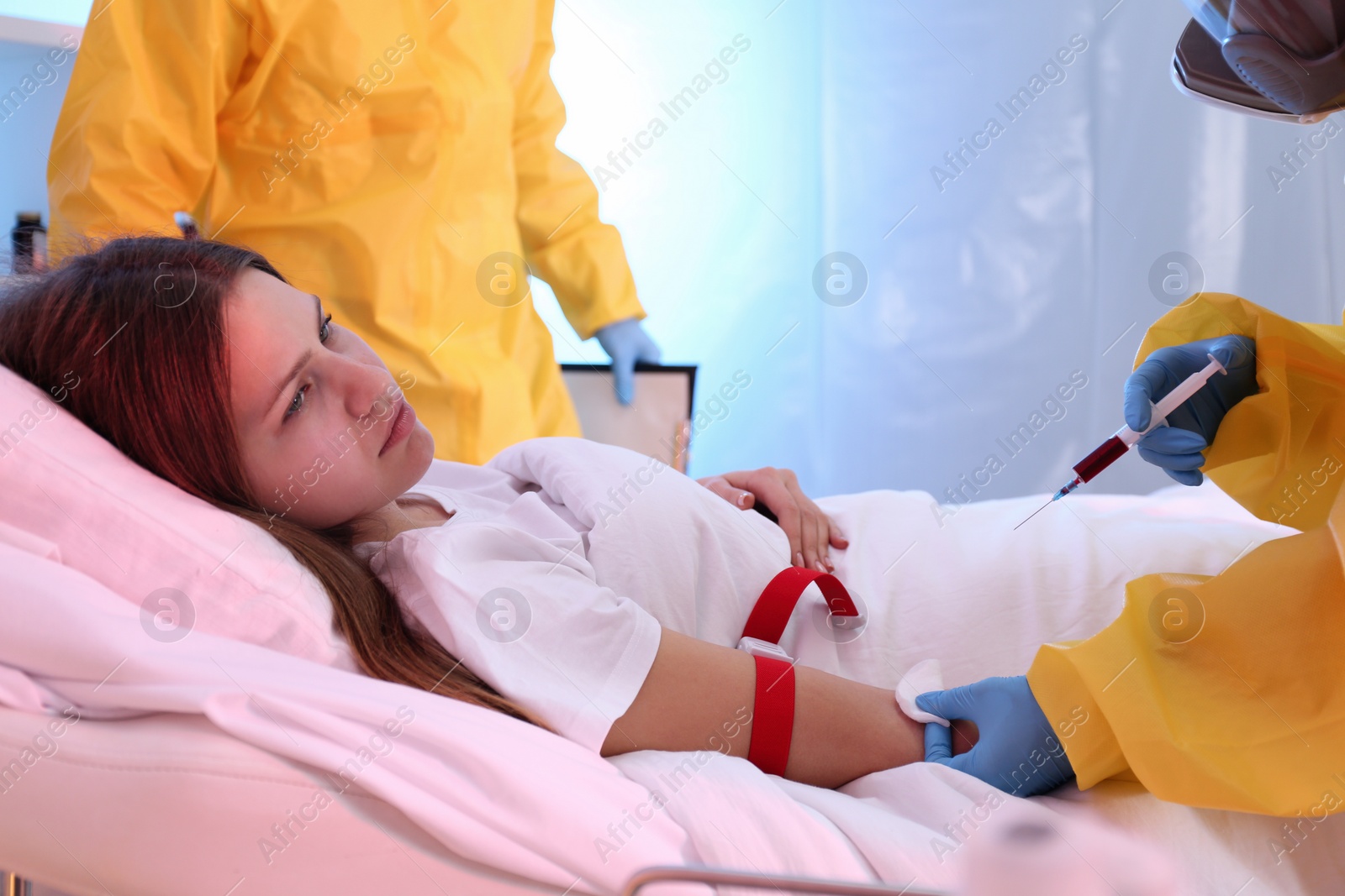 Photo of Professional paramedics injecting vaccine to patient with virus in quarantine ward, closeup