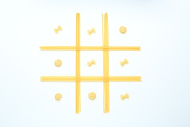 Tic tac toe game made with different types of pasta isolated on white, top view