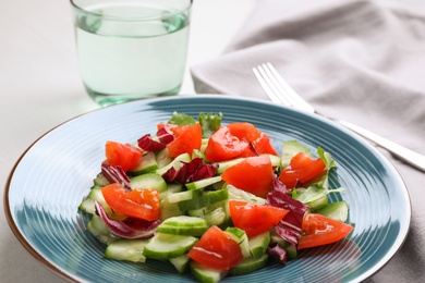 Photo of Delicious fresh cucumber tomato salad served on table