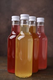 Photo of Delicious kombucha in glass bottles on wooden table