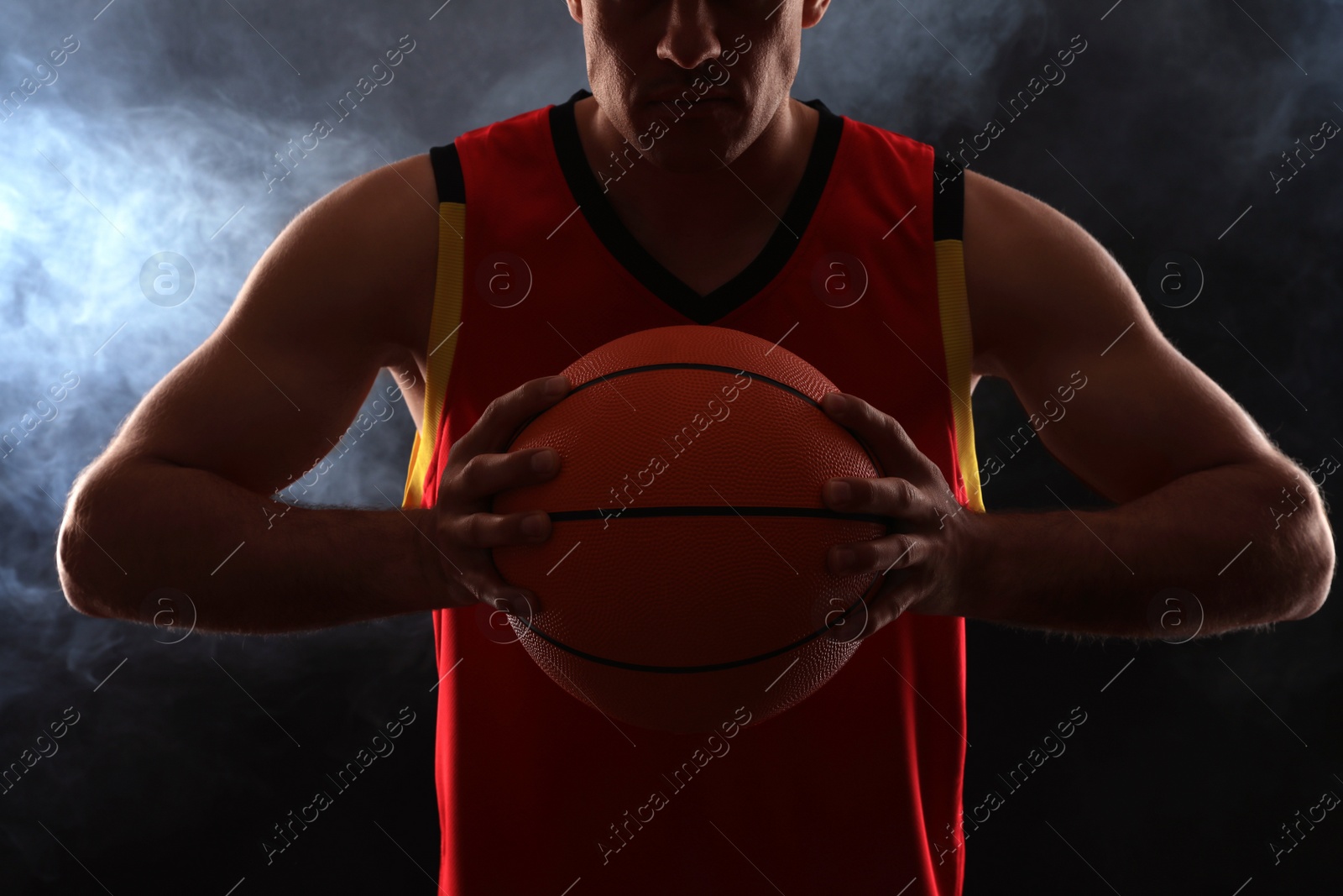 Photo of Basketball player with ball on black background, closeup