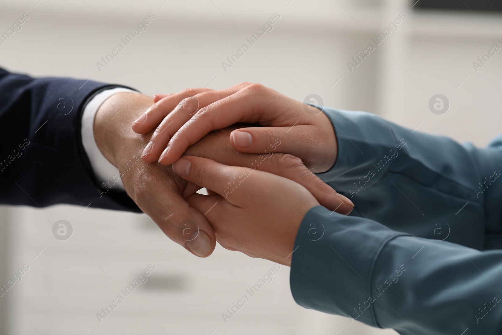 Photo of Trust and deal. Man with woman joining hands on blurred background, closeup