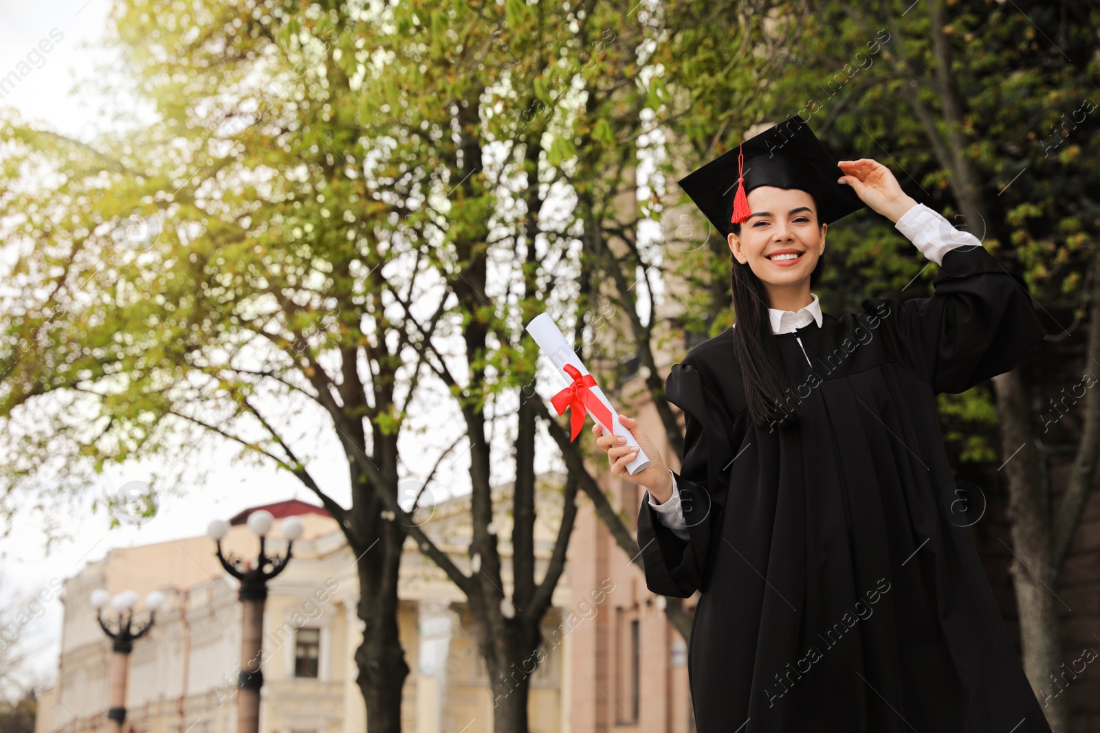 Photo of Happy student with diploma after graduation ceremony outdoors. Space for text