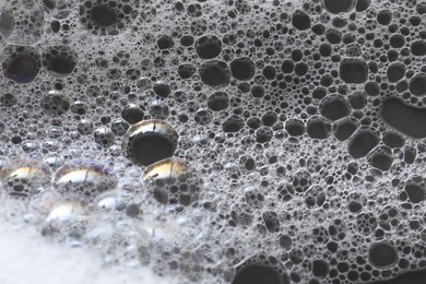 Photo of White washing foam on dark gray background, closeup